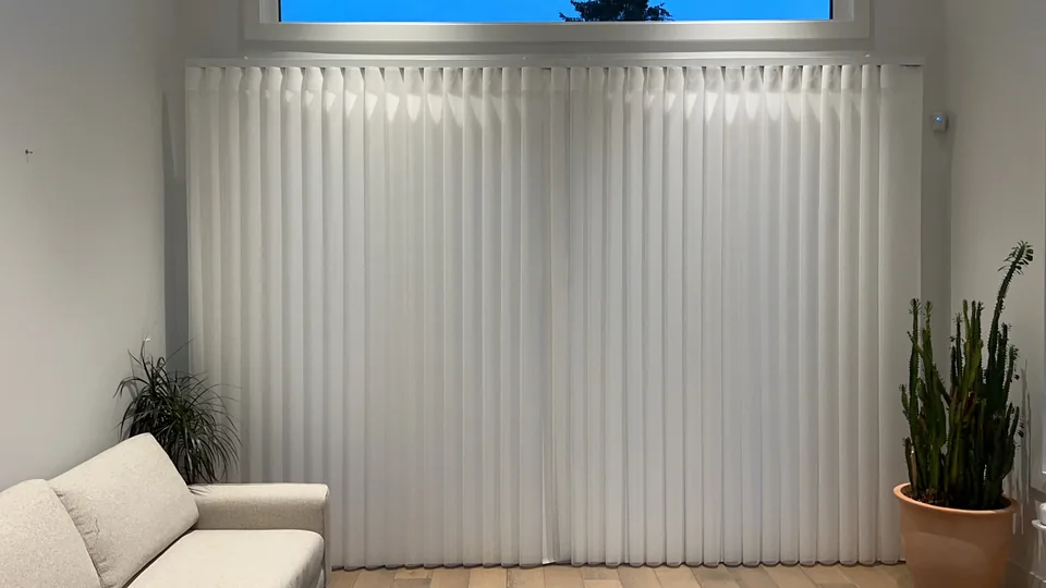 White Dream Curtain panels aligned across the opening beside a sofa and plants