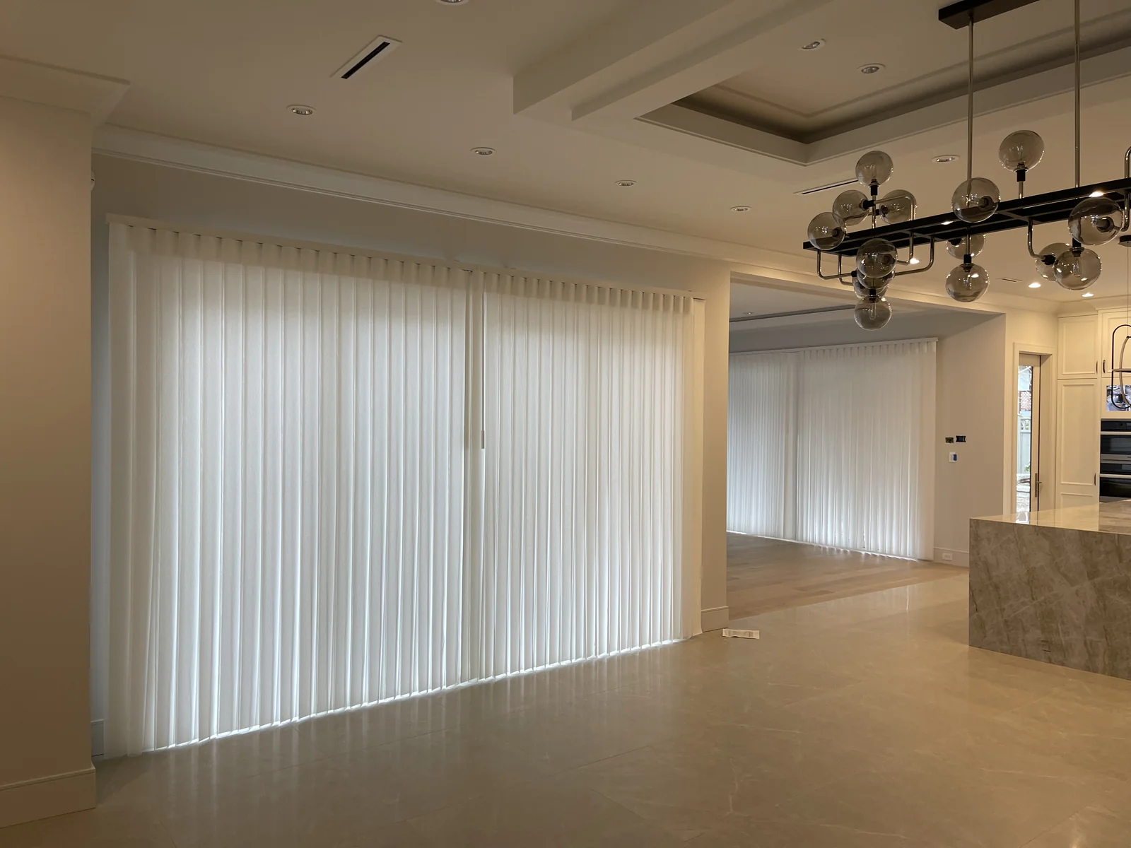 White dream curtains across two wide openings beside an open-plan kitchen and dining area