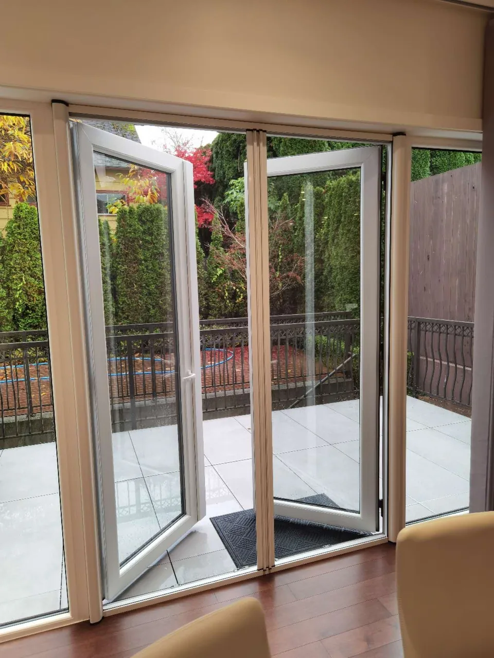 Screen-door frames sit within a wide garden opening, shown partly open