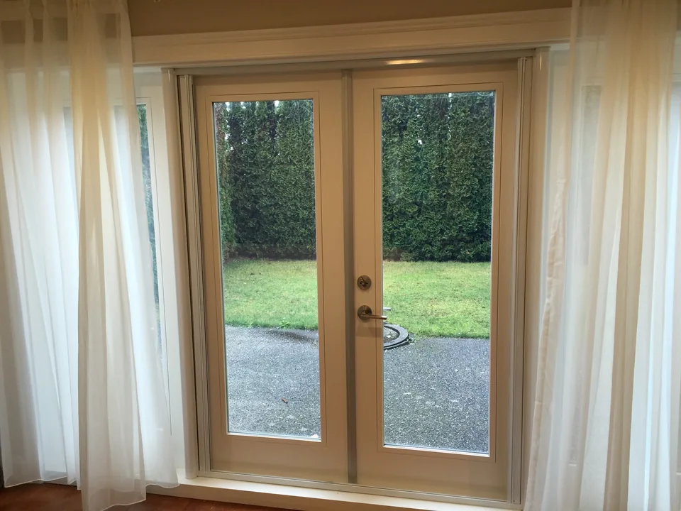 Light sheer curtains sit to either side of glazed garden doors