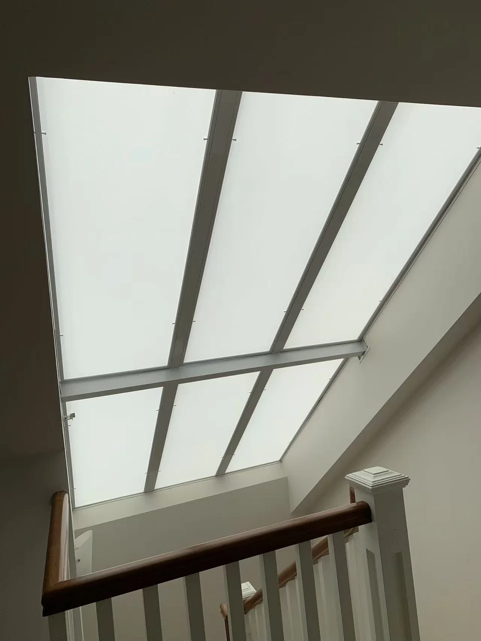 Six removable light-filtering fabric frames installed above the same staircase