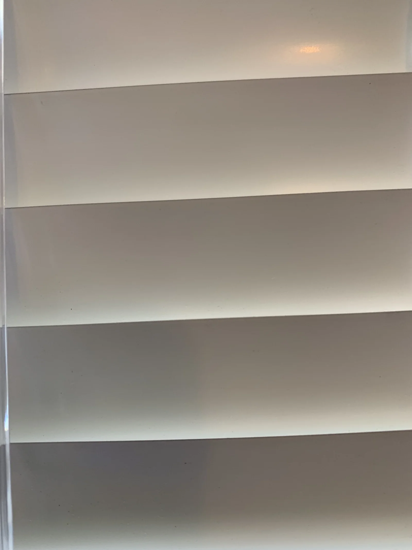 Close view of softly curved white fabric vanes and sheer layers in a Vienna shade