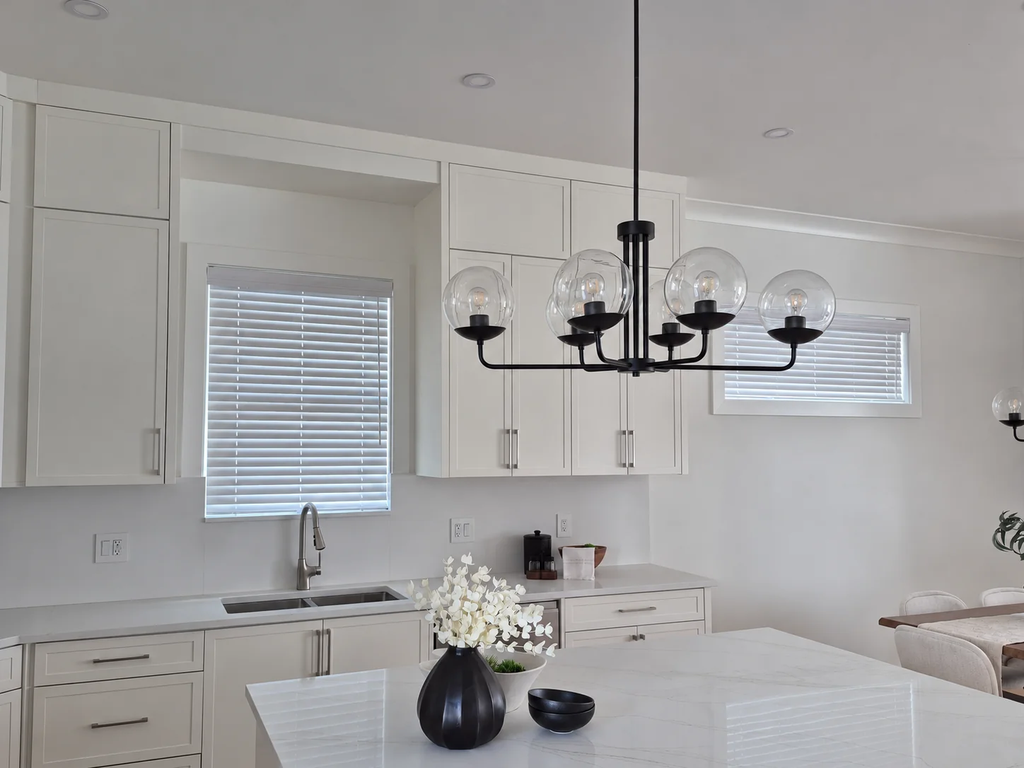 Regular AAA SheathCord white faux wood blinds coordinated with cabinetry in a bright kitchen